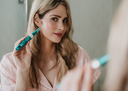 Woman holding Dr Pen A6S Microneedling pen to her face