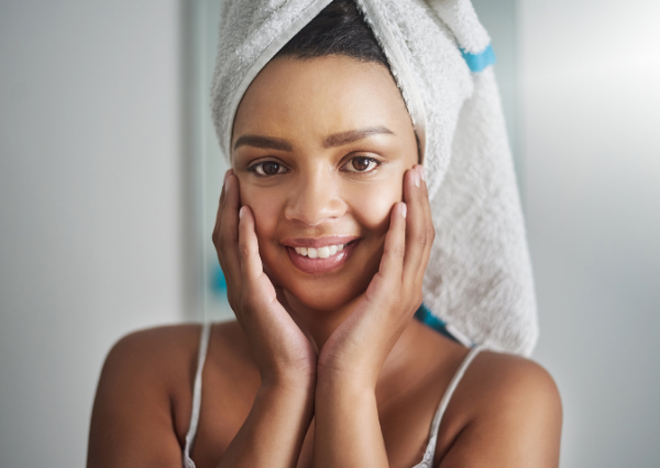  Woman with hair wrapped in a towel, touching her hands to her face