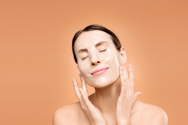 Closeup of woman using a sheet mask to moisturise her face
